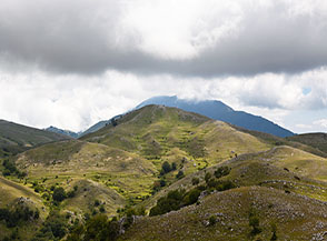 I verdi pascoli del Monte Le Catenelle con sullo sfondo, in ombra, il Monte Cairo.