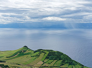 Vista a mare dal Miradouro Ferr&atilde; Afonso, sullo sfondo l&rsquo;Isola di Pico.