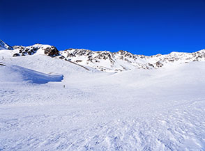 L&rsquo;immensa distesa di neve del Pian del Desinare, il picco centrale sullo sfondo &egrave; la Roccia della Grande Tempesta.