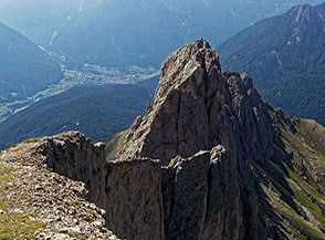 Scorcio sul bordo della strapiombante Parete Ovest della Roda de Vael con cima del Masar&egrave; alle sue spalle.