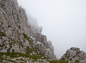 Le nuvole nascondono il precipizio roccioso dello Spigolo Sud di Sasso Borghese.
