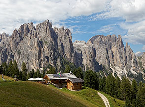 La baita di Pra&rsquo; Martin con vista sulle Pale del Mesd&igrave; e le torri di Punta Scalpello (sulla dx).