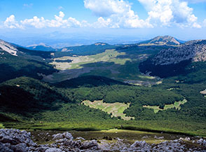Vista sulla Fossa del Lupo e i verdi pascoli dei Piani di Pollino, il meraviglioso panorama goduto dall&rsquo;Anticima Settentrionale di Serra Dolcedorme.