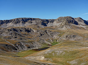 I prati verde e oro dell&rsquo;Autunno e la cresta rocciosa di Serra Rocca Chiarano incorniciano il Lago Pantaniello che si scopre pian piano.
