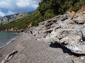 Il cordone di rocce modellato in suggestive forme che cinge la Spiaggia della Molara.