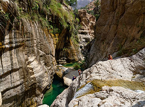 Una fune ci viene in aiuto per scendere sulle liscie placche modellate dall&rsquo;acqua (Wadi Mibam).