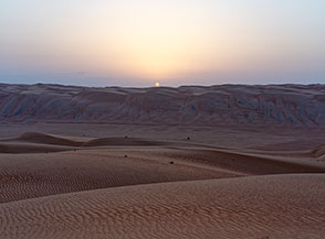 Un &ldquo;freddo&ldquo; Sole compare all&rsquo;orizzonte sulle alte dune del Wahiba Sands&hellip;